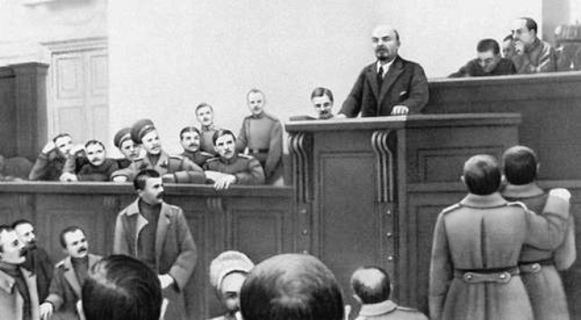 Ленин выступает в Таврическом дворце. Его призыв к социалистической революции вызывает недоумение. Посмотрите на лица присутствующих в зале заседания
