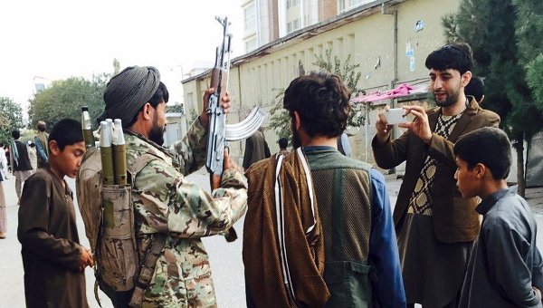 Боевики движения Талибан фотографируются на улице города Кундуз, Афганистан